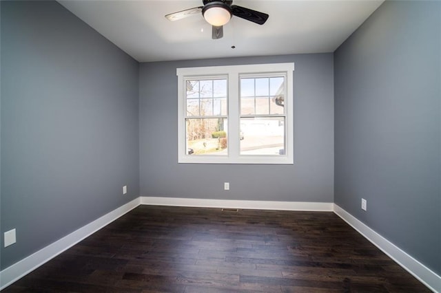 empty room featuring a ceiling fan, baseboards, and dark wood-style flooring