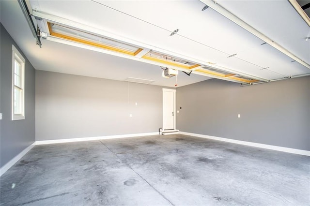 garage with a garage door opener and baseboards