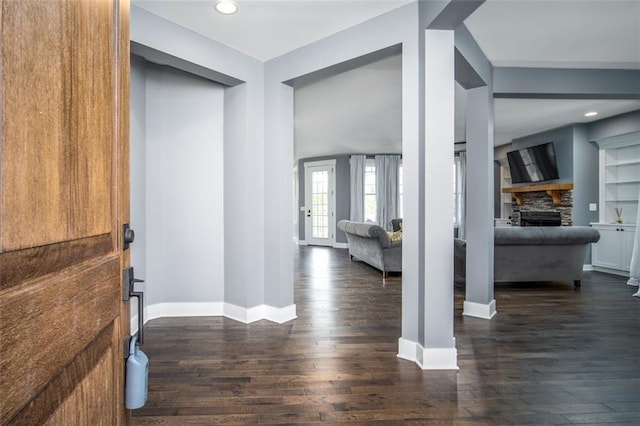 entryway featuring a stone fireplace, recessed lighting, baseboards, and dark wood-style flooring