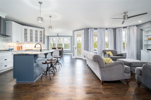 living area featuring recessed lighting, baseboards, dark wood-type flooring, and a ceiling fan