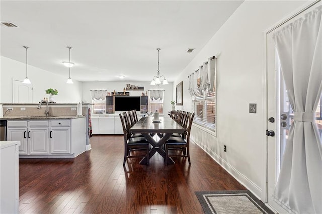 dining space featuring plenty of natural light, dark hardwood / wood-style floors, a chandelier, and sink