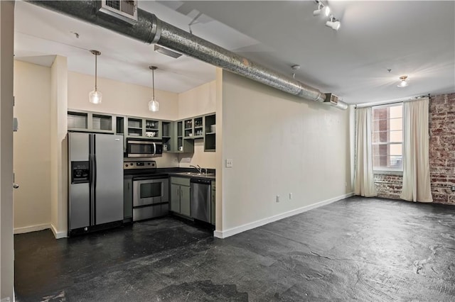 kitchen with rail lighting, brick wall, stainless steel appliances, pendant lighting, and sink