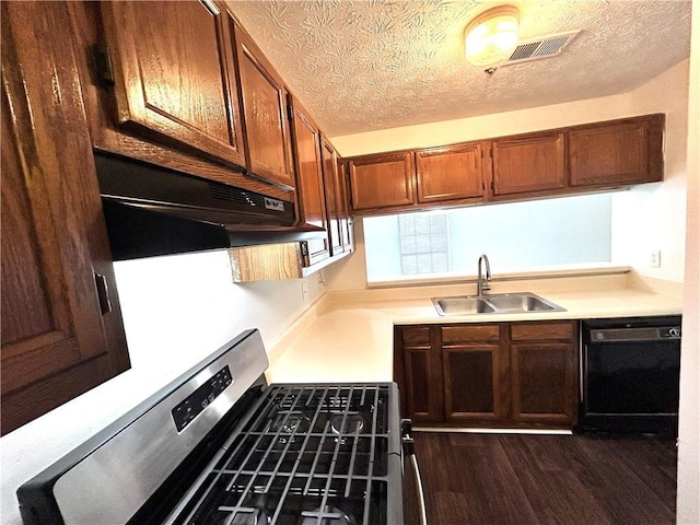 kitchen with black dishwasher, sink, gas range, dark wood-type flooring, and a textured ceiling