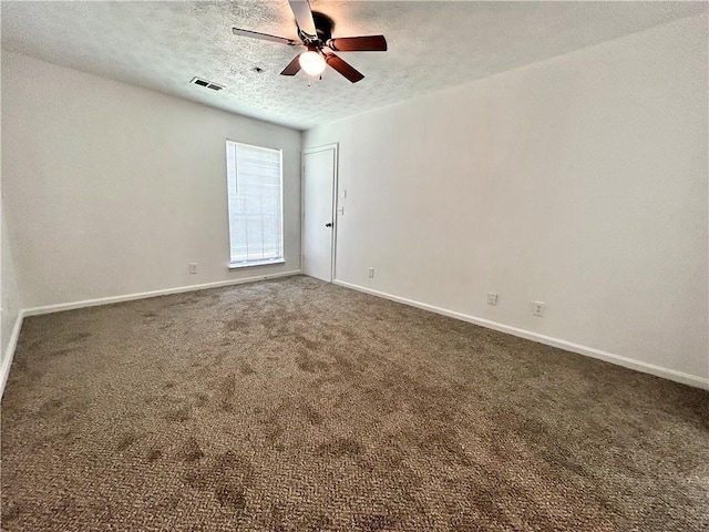 carpeted empty room with ceiling fan and a textured ceiling