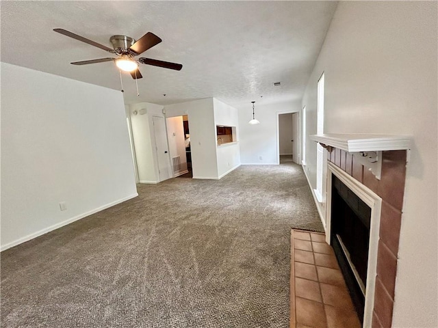 unfurnished living room featuring ceiling fan, carpet floors, and a textured ceiling