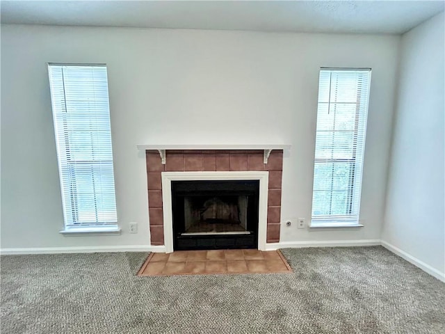 details with a tile fireplace and carpet