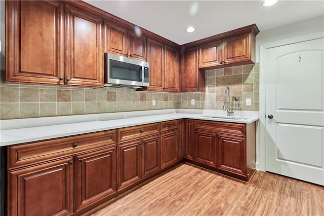 3690 Dalwood Dr, Suwanee, GA 30024 - kitchen featuring sink, decorative backsplash, and light wood-type flooring