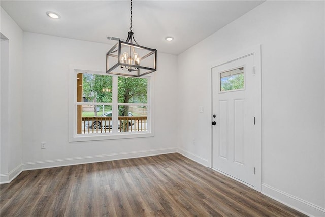 foyer with dark wood-type flooring, visible vents, baseboards, and an inviting chandelier