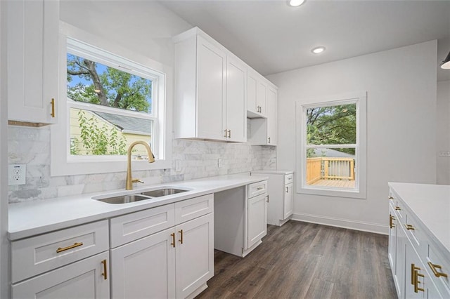kitchen with dark wood-style floors, light countertops, a sink, decorative backsplash, and white cabinetry