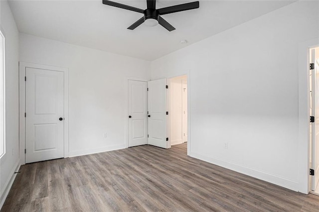 unfurnished bedroom with ceiling fan, baseboards, and wood finished floors