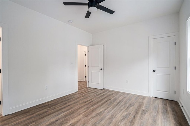 spare room featuring wood finished floors, baseboards, and ceiling fan