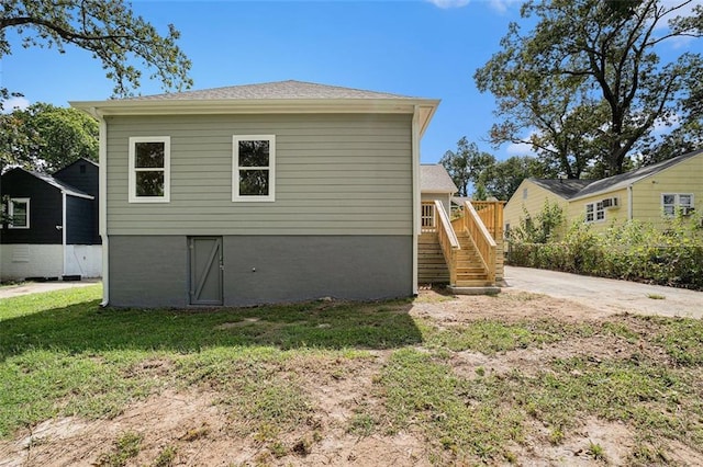 view of home's exterior with a lawn and stairway