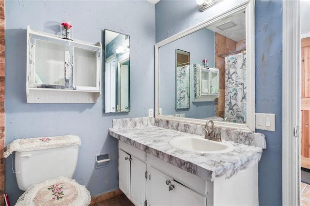 bathroom featuring a shower with curtain, vanity, and toilet