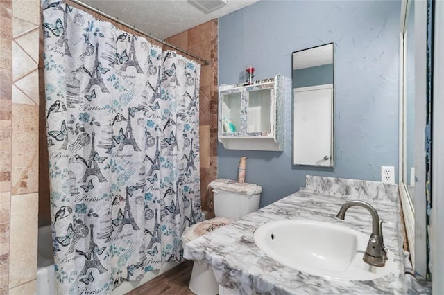 bathroom featuring a textured ceiling, vanity, and toilet