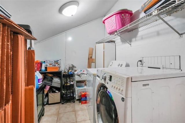 clothes washing area with light tile patterned floors and washer and dryer