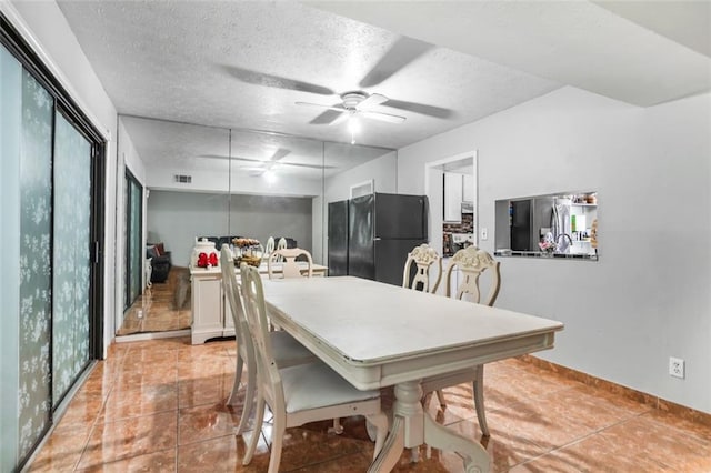 dining area featuring light tile patterned floors, a textured ceiling, and ceiling fan