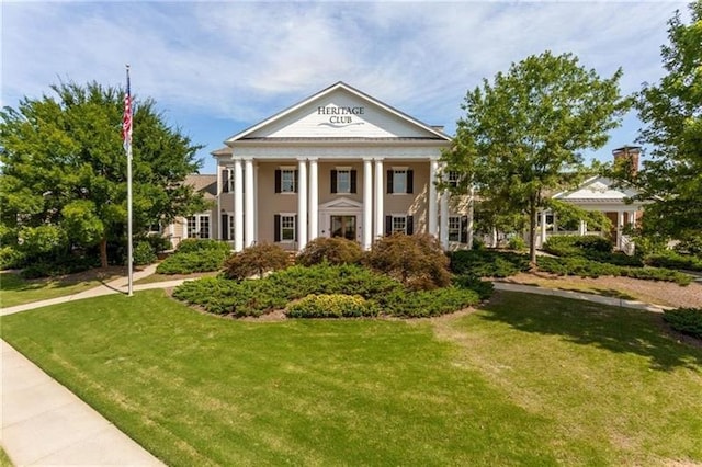 greek revival inspired property with a front yard