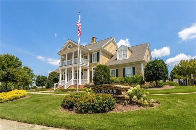 view of front of property with a balcony and a front yard