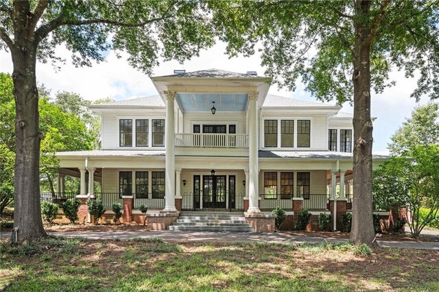 back of house with covered porch and french doors