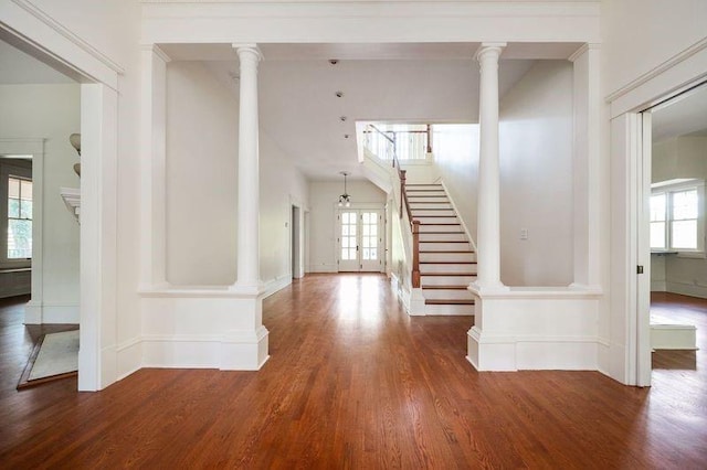 foyer featuring ornate columns and dark hardwood / wood-style floors