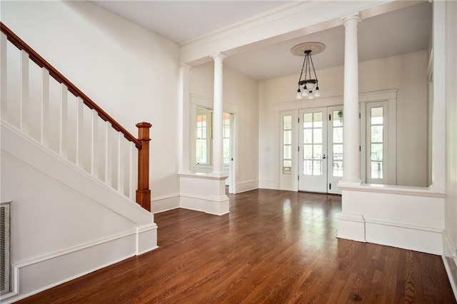 foyer with decorative columns, a wealth of natural light, and dark hardwood / wood-style flooring