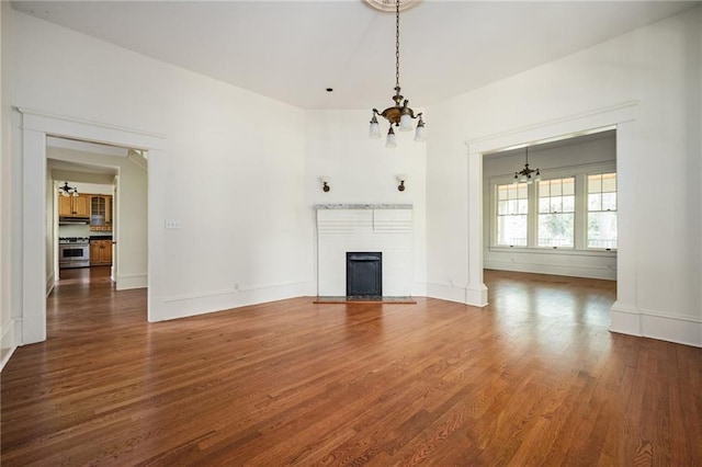 unfurnished living room with dark wood-type flooring and an inviting chandelier