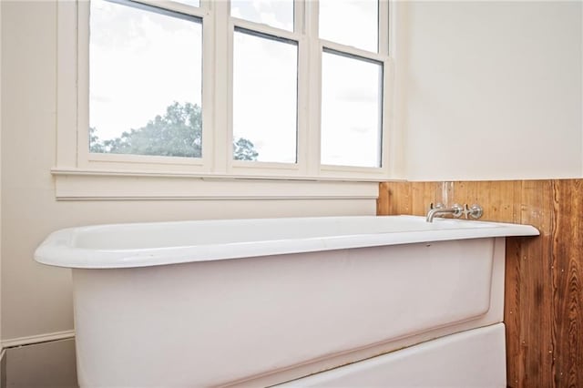 bathroom featuring a tub to relax in and a wealth of natural light