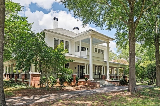 rear view of house with a porch and a balcony