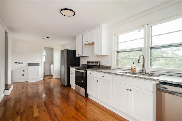 kitchen with sink, ornamental molding, dark hardwood / wood-style flooring, stainless steel appliances, and white cabinets