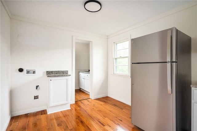 laundry area featuring hookup for a washing machine, crown molding, and light wood-type flooring