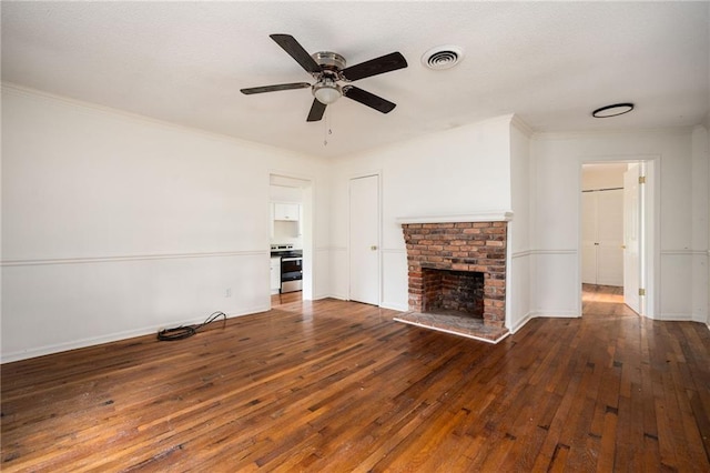 unfurnished living room with dark wood-type flooring, crown molding, and a brick fireplace