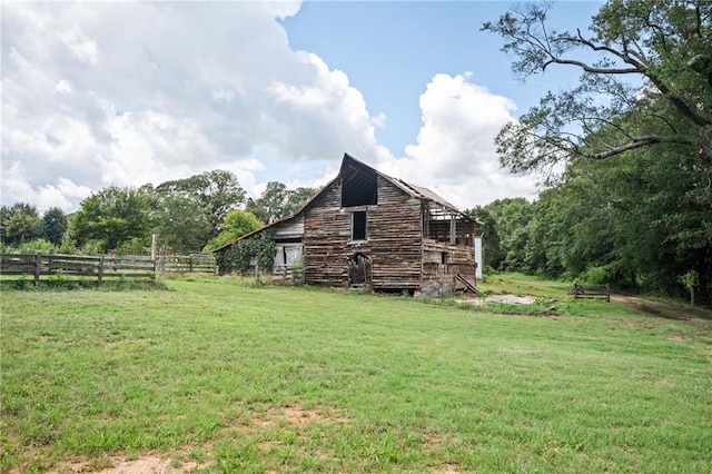 view of property exterior featuring a lawn and an outdoor structure