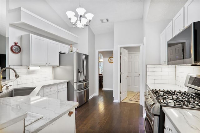 1610 Trellis Xing, Alpharetta, GA 30004 - kitchen with appliances with stainless steel finishes, light stone countertops, a chandelier, dark wood-style flooring, and white cabinets