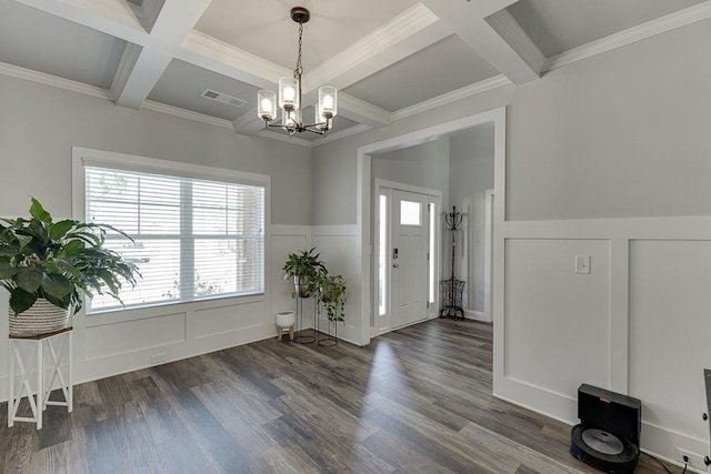 entrance foyer featuring dark hardwood / wood-style flooring, coffered ceiling, a notable chandelier, crown molding, and beam ceiling