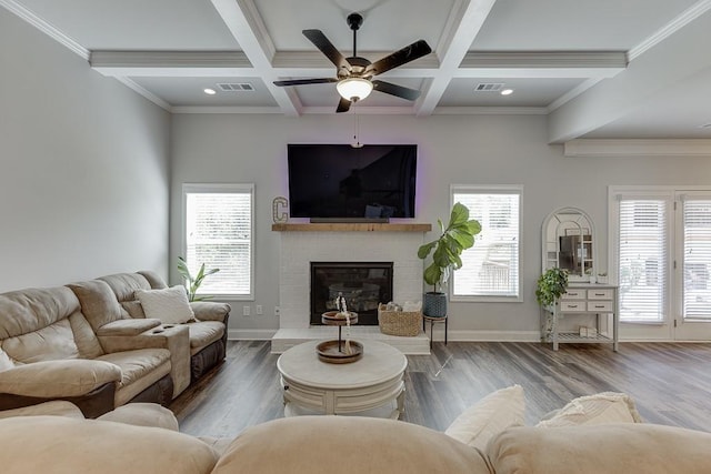 living room with hardwood / wood-style floors, a wealth of natural light, a fireplace, and beamed ceiling