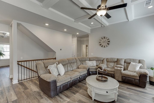 living room featuring ceiling fan, coffered ceiling, wood-type flooring, ornamental molding, and beamed ceiling