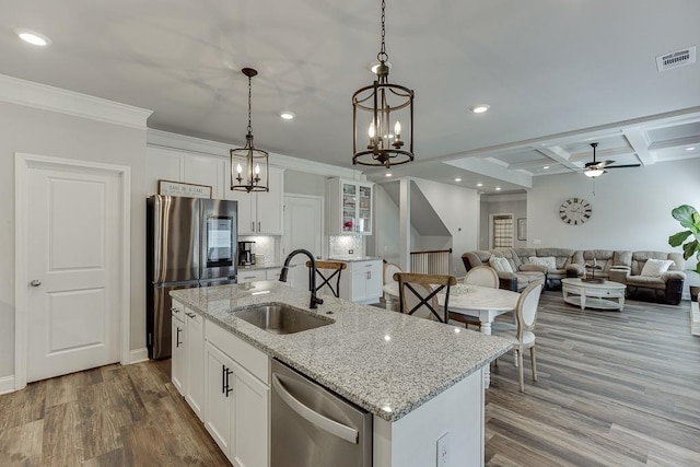 kitchen with appliances with stainless steel finishes, sink, a center island with sink, and white cabinets