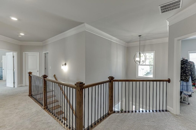 corridor featuring crown molding, light colored carpet, and a notable chandelier