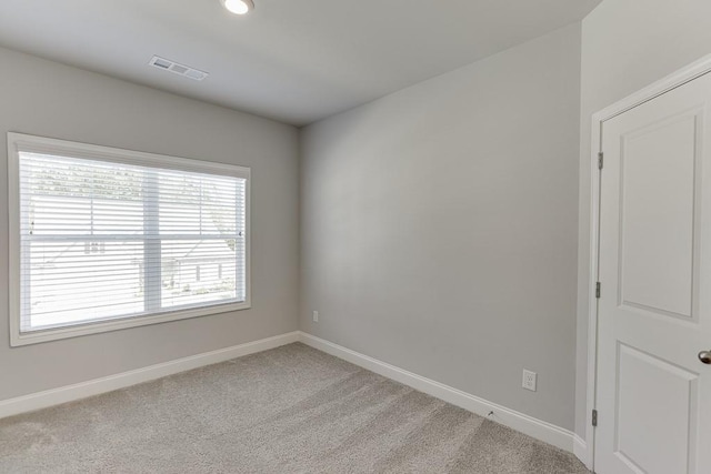 spare room featuring light colored carpet