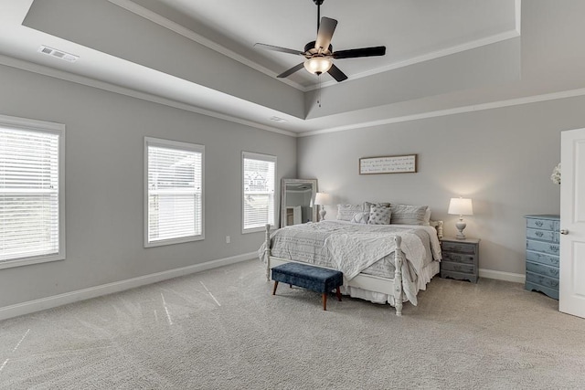 bedroom with crown molding, a tray ceiling, light colored carpet, and ceiling fan