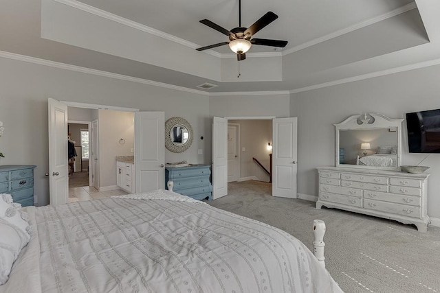 carpeted bedroom with crown molding, ceiling fan, ensuite bathroom, and a raised ceiling