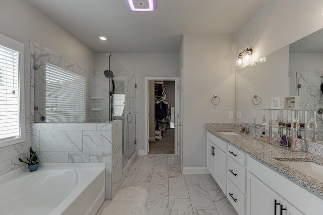 bathroom featuring a healthy amount of sunlight, separate shower and tub, and vanity