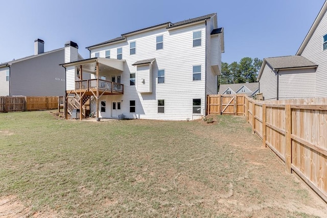 back of property featuring a wooden deck and a lawn