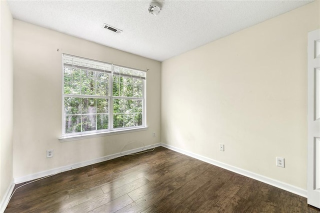 empty room featuring wood finished floors, baseboards, a textured ceiling, and a smoke detector