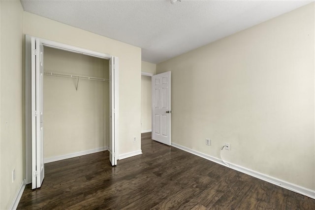 unfurnished bedroom with wood finished floors, baseboards, a closet, and a textured ceiling