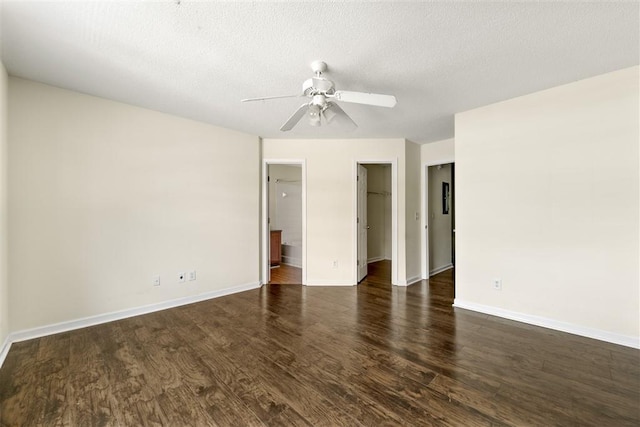 unfurnished room with dark wood finished floors, a ceiling fan, baseboards, and a textured ceiling