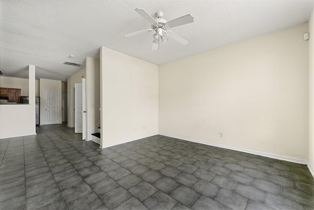 empty room featuring a ceiling fan, a textured ceiling, and baseboards