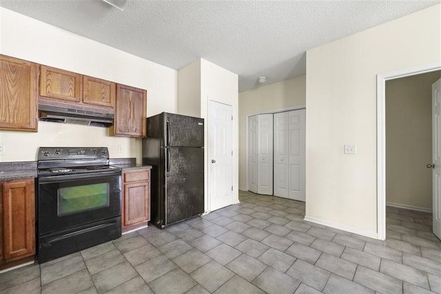 kitchen featuring black appliances, under cabinet range hood, dark countertops, brown cabinets, and a textured ceiling