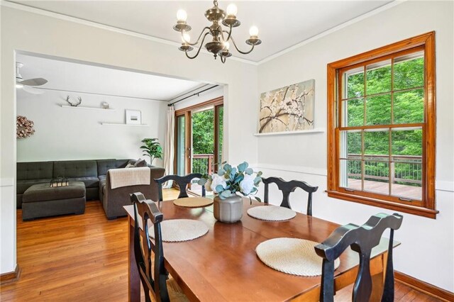 dining room with a chandelier, wood finished floors, and crown molding