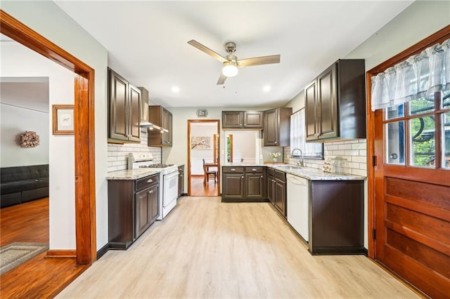 kitchen featuring white appliances, a ceiling fan, light wood-type flooring, a sink, and backsplash